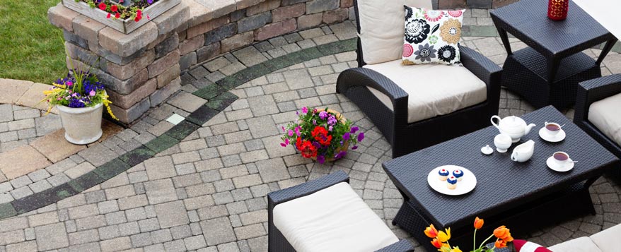 Gartenmöbel aus dunklem Rattan ergänzen sich perfekt mit hellen Polstern zu einer stilvollen Terrassen-Gruppe