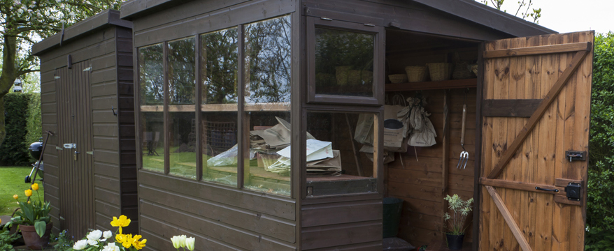 Ein Geräteschuppen aus Holz im Garten ist gleichzeitig dekorativ und praktisch