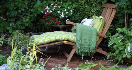 Mit Kissen und Decke wird die Sonnenliege im Garten richtig gemütlich