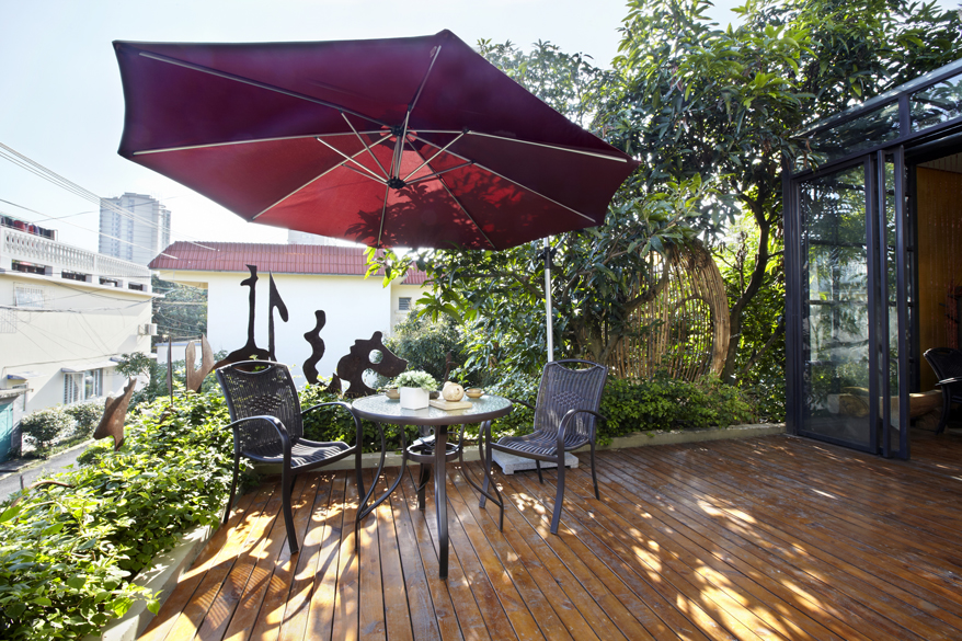 Ein Sonnenschirm spendet dem Balkon Schatten und sieht toll aus