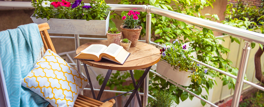 Blumen und Kräuter in Balkonkästen und Terrakotta-Töpfen sind farbenfrohe Tupfer auf dem Balkon