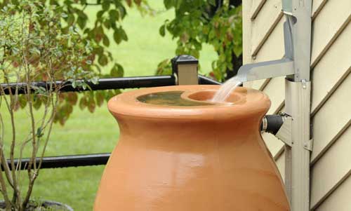 Mit Regenrinne und Tonne kann Wasser einfach aufgefangen werden