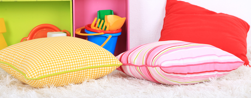 Große Kissen und ein weicher, hochfloriger Teppich machen die Kuschelecke für Kinder gemütlich