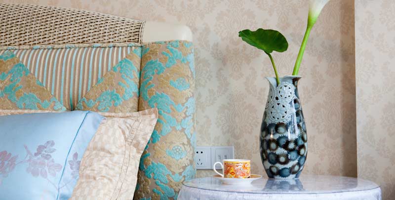 Blumenmuster und Pastellfarben auf Sofa, Kissen und Accessoires prägen den romantischen Wohnstil