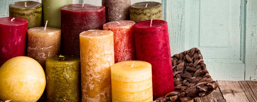Kerzen in Honiggelb, Burgund, Orange und Moosgrün holen das herbstliche Farbspiel ins Haus